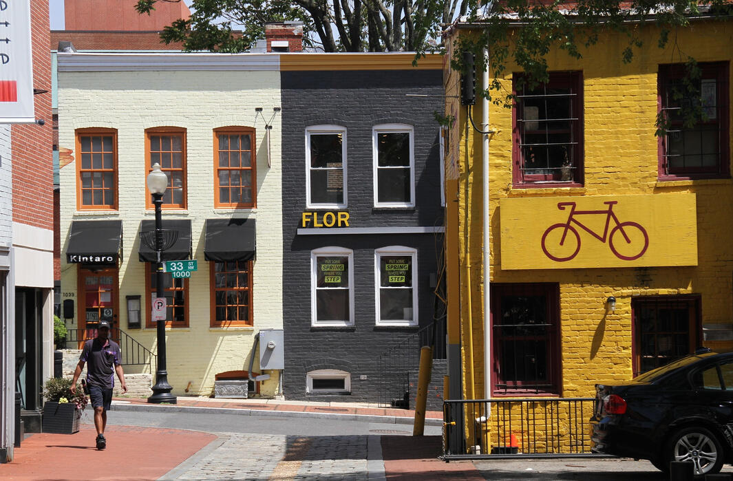 Buildings in Georgetown, including a white, grey and yellow building. The yellow building has a bike logo on the sign.